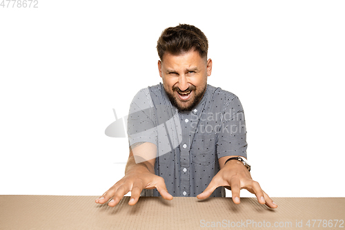 Image of Shocked and upset man opening the biggest postal package