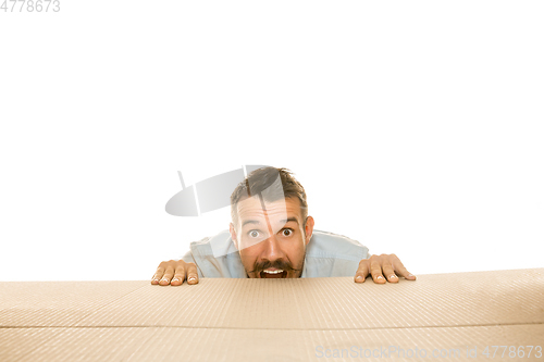 Image of Young man opening the biggest postal package isolated on white