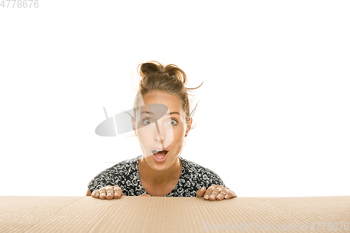 Image of Young woman opening the biggest postal package isolated on white