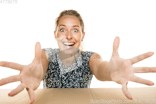 Image of Young woman opening the biggest postal package isolated on white