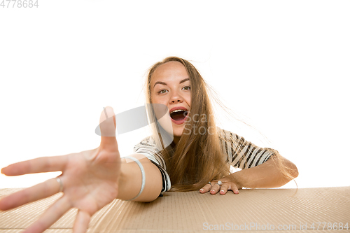 Image of Young woman opening the biggest postal package isolated on white