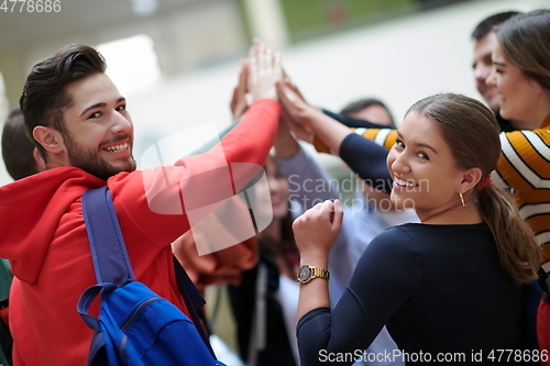 Image of students together in problem, arm in the air