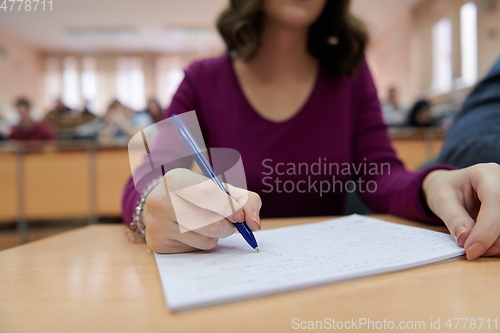 Image of famale student using pen and notebook