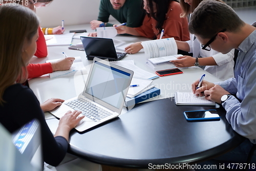 Image of students group working on school project together on tablet computer at modern university