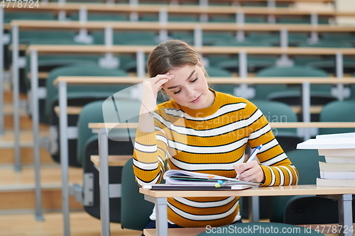 Image of student taking notes for school class