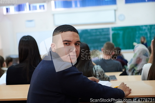 Image of student taking notes while studying in high school