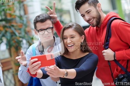 Image of Group of multiethnic teenagers taking a selfie in school