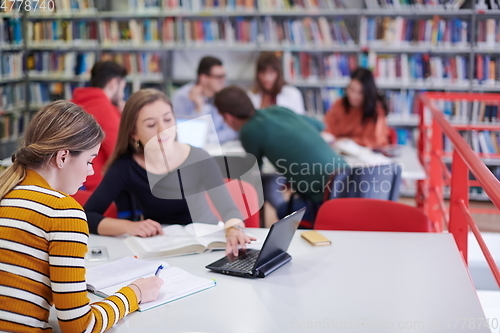 Image of the student uses a notebook and a school library