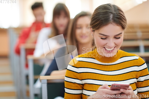 Image of famel students using smartphone in classroom