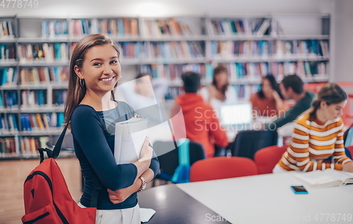 Image of the student uses a notebook and a school library