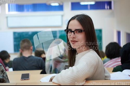 Image of girl sitting in an amphitheater and talking to her colleagues