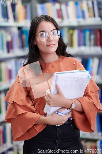 Image of the student uses a notebook and a school library