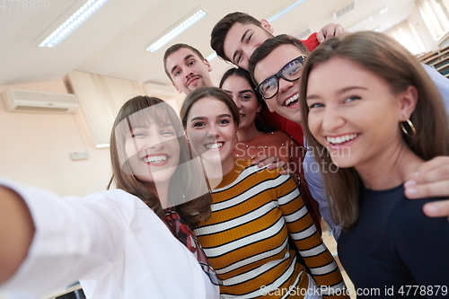 Image of Group of multiethnic teenagers taking a selfie in school