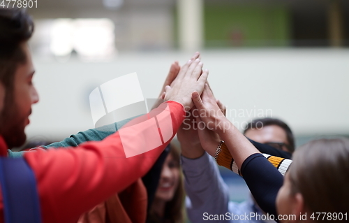 Image of students together in problem, arm in the air