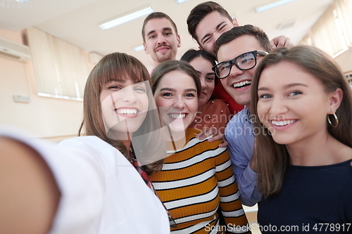 Image of Group of multiethnic teenagers taking a selfie in school