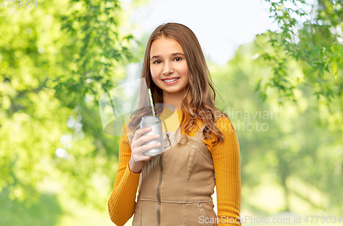 Image of happy teenage girl drinking soda from can