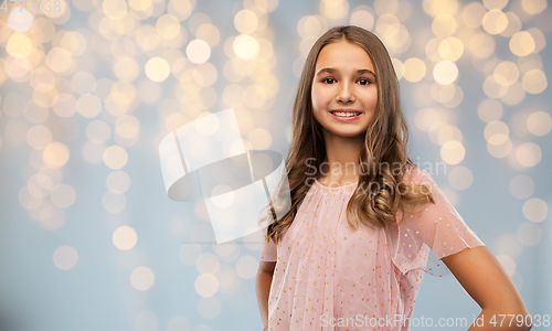 Image of smiling teenage girl in party dress over lights