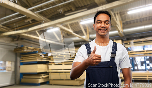 Image of happy indian worker showing thumbs up at warehouse