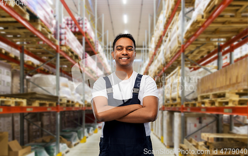 Image of happy indian worker with crossed arms at warehouse