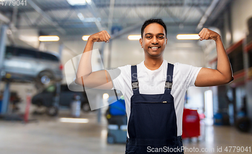 Image of indian mechanic showing his power at car shop