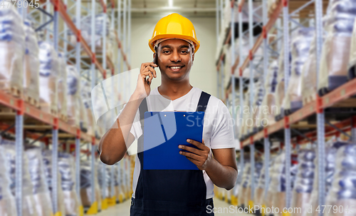 Image of indian worker calling on smartphone at warehouse