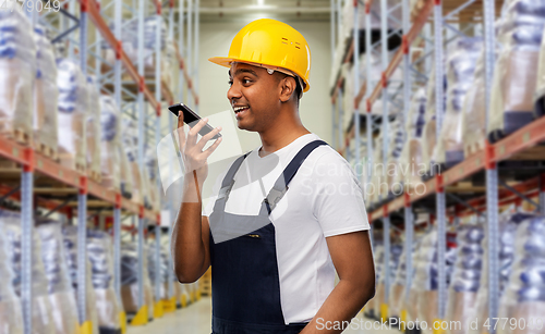 Image of happy indian loader recording voice on smartphone