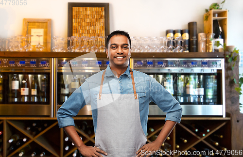 Image of smiling indian barman or waiter at wine bar