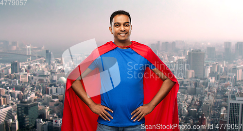 Image of happy indian man in superhero cape in tokyo city