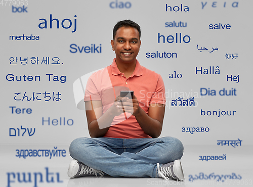 Image of happy indian man using smartphone