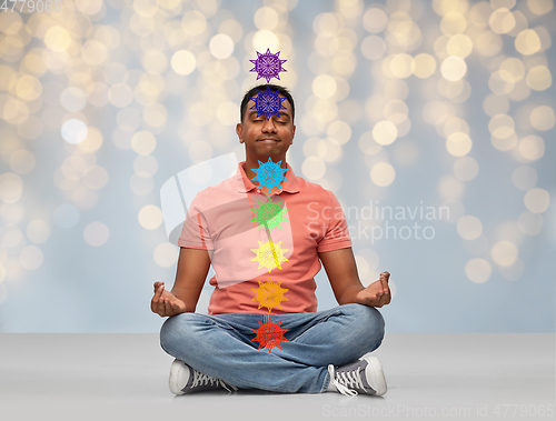 Image of happy indian man meditating in lotus yoga pose