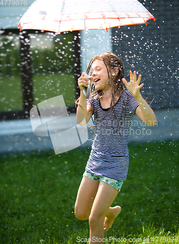 Image of Happy girl is playing under rain