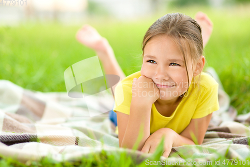 Image of Portrait of a little girl laying on green grass