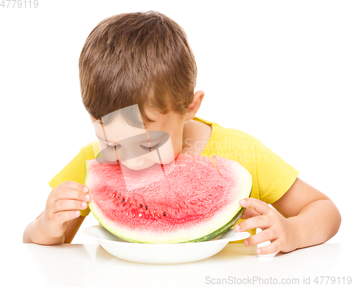 Image of Little boy is eating watermelon