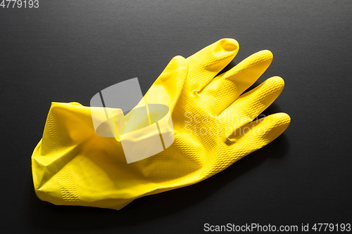 Image of yellow rubber glove isolated on black background