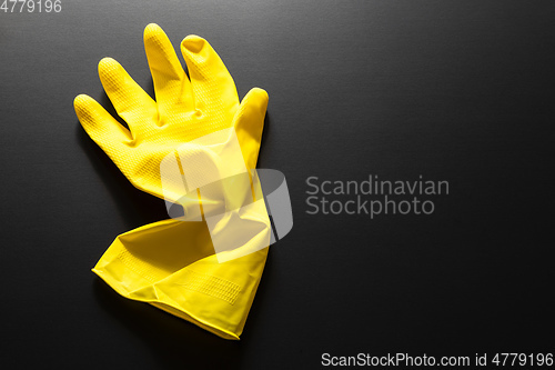 Image of yellow rubber glove isolated on black background