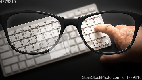 Image of glasses with keyboard sharp and blurred