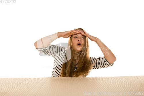 Image of Young woman opening the biggest postal package isolated on white