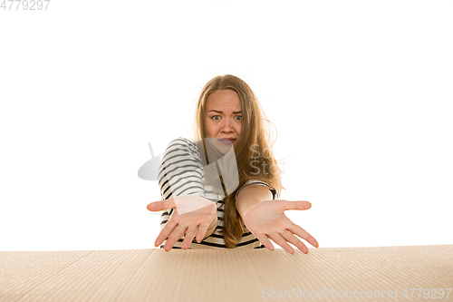 Image of Young woman opening the biggest postal package isolated on white