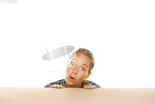 Image of Young woman opening the biggest postal package isolated on white