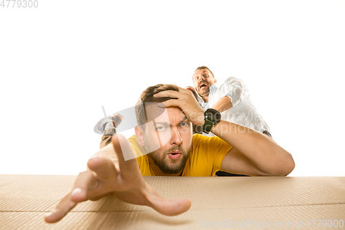 Image of Young man opening the biggest postal package isolated on white