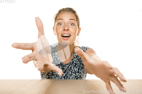 Image of Young woman opening the biggest postal package isolated on white