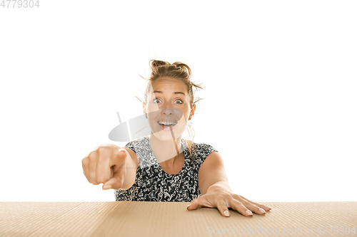 Image of Young woman opening the biggest postal package isolated on white