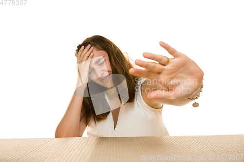 Image of Young woman opening the biggest postal package isolated on white