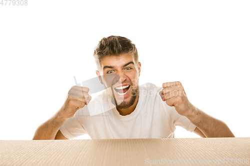 Image of Young man opening the biggest postal package isolated on white