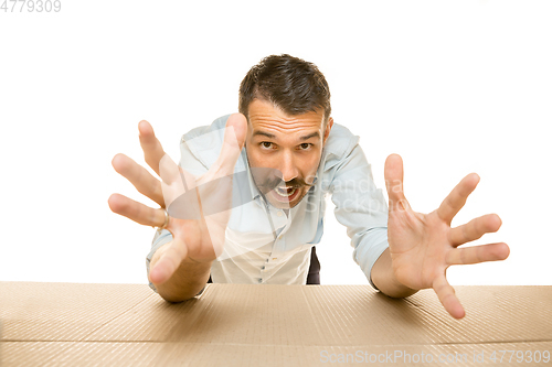 Image of Young man opening the biggest postal package isolated on white