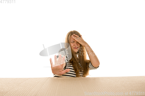 Image of Young woman opening the biggest postal package isolated on white