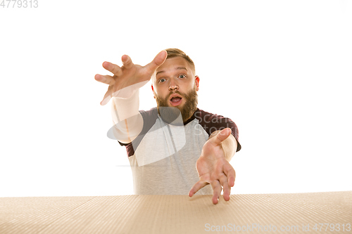 Image of Young man opening the biggest postal package isolated on white