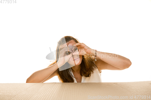 Image of Young woman opening the biggest postal package isolated on white