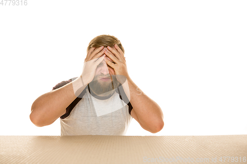 Image of Young man opening the biggest postal package isolated on white