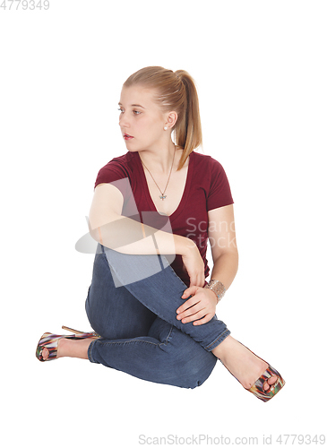Image of Beautiful young woman sitting on floor